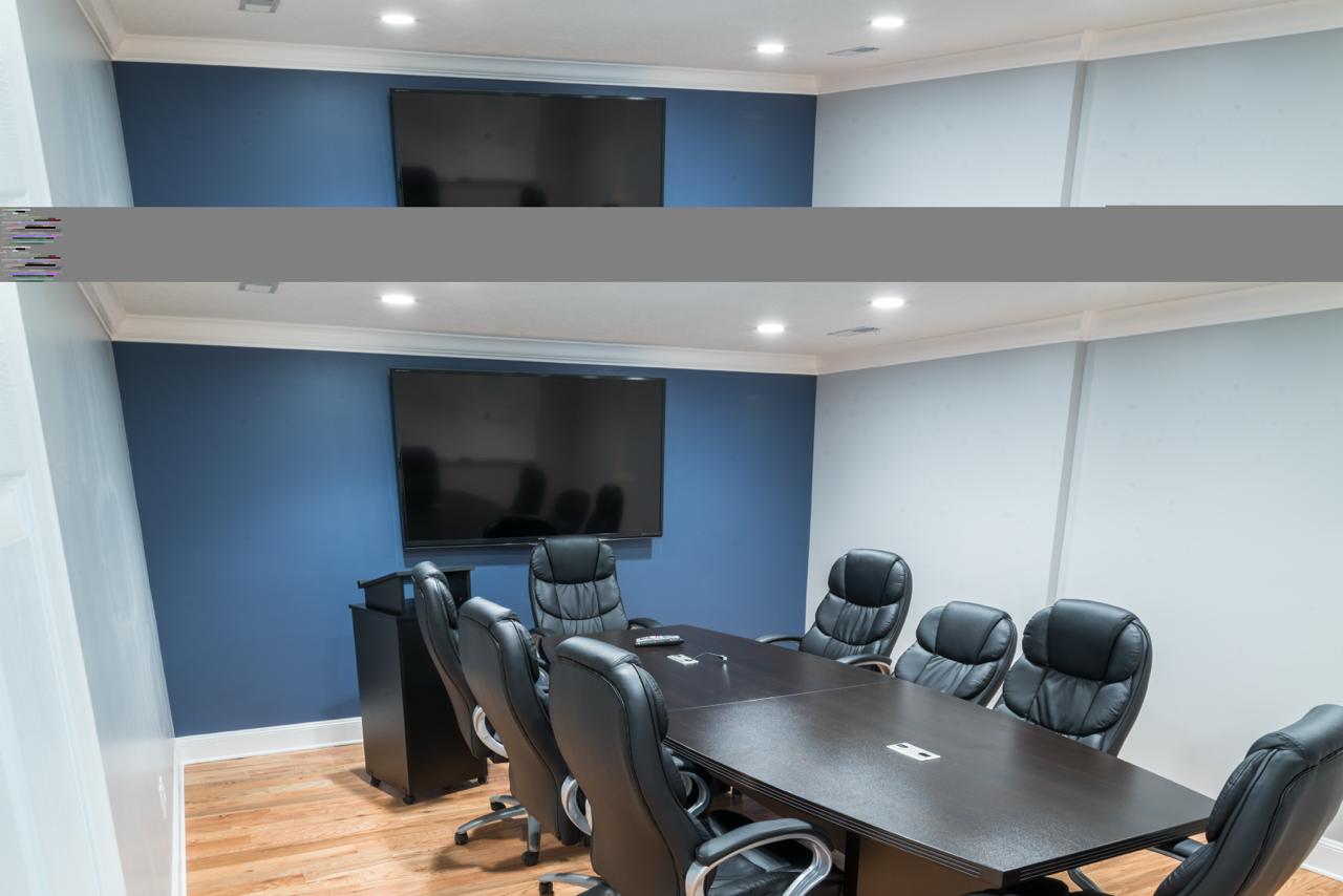 Five Point Restoration professional conference room with large table, leather chairs, blue accent wall, and presentation TV
