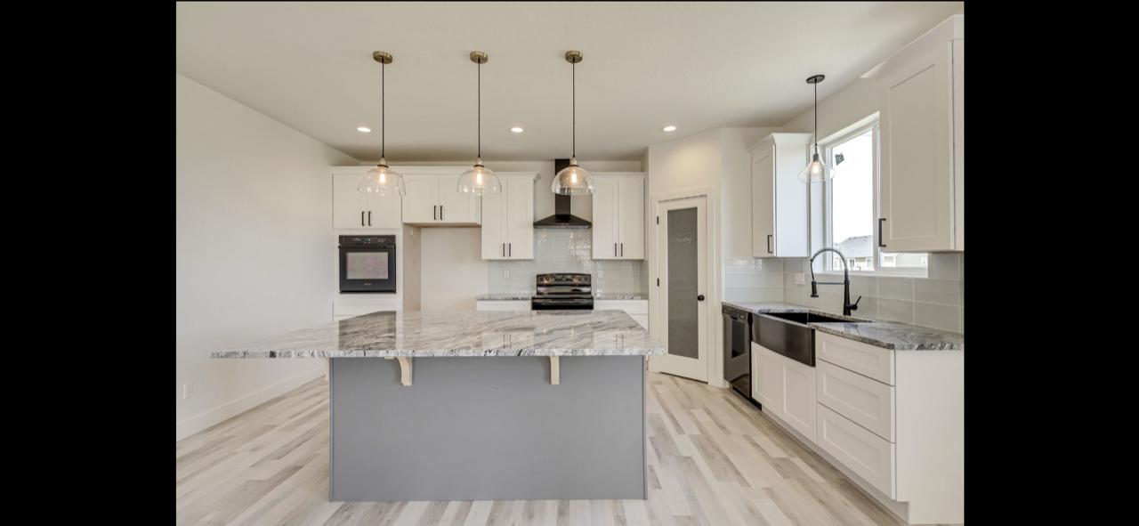 Fully restored kitchen with white cabinets and granite island - completed by Five Point Restoration